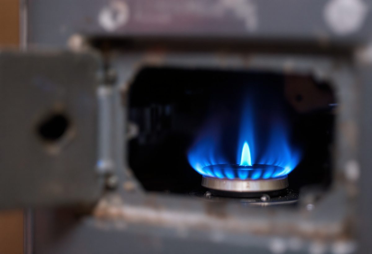 Small blue pilot light flame on an older gas furnace